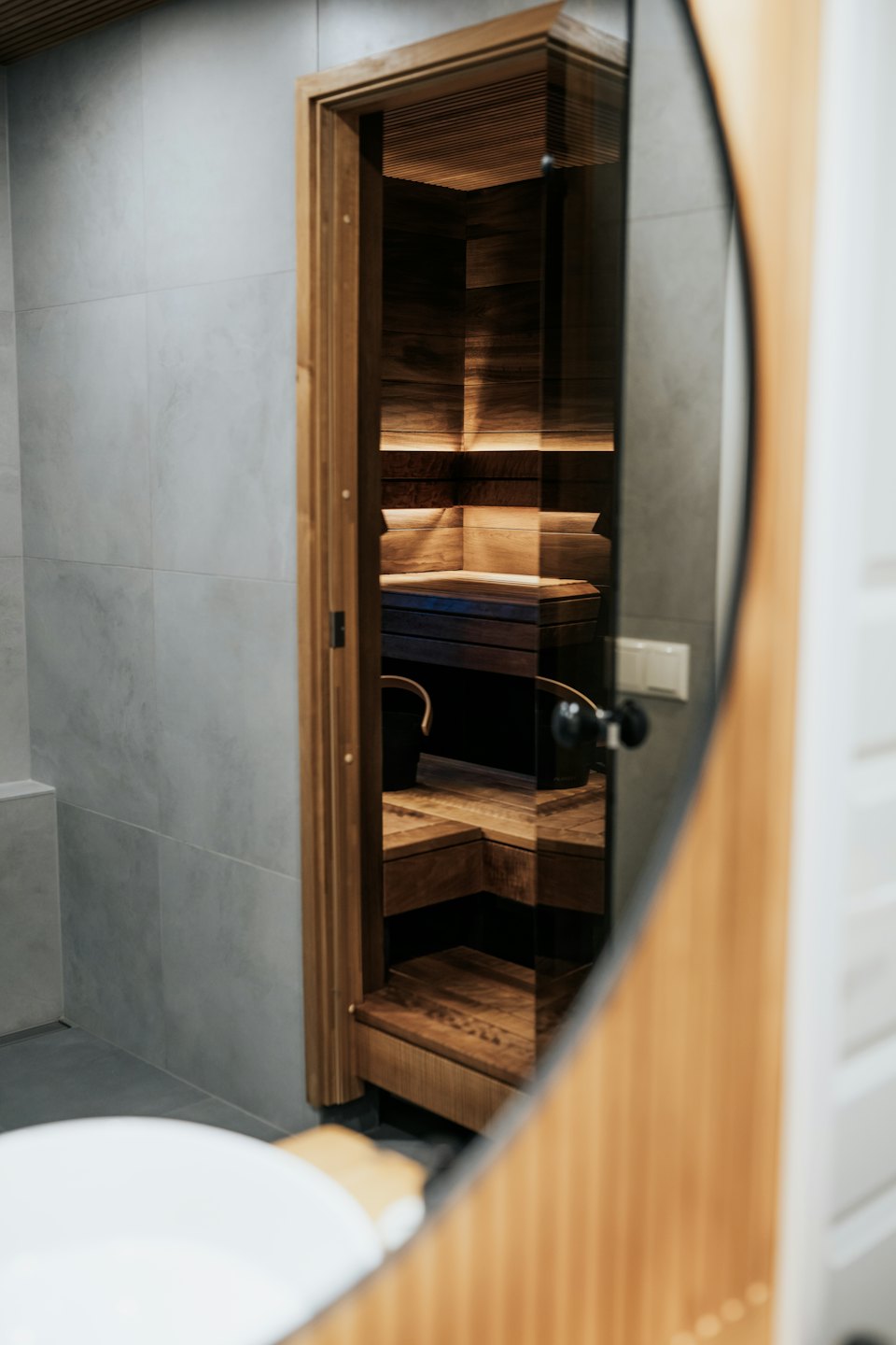 Moderni sauna kylpyhuoneen lasioven läpi katsottuna.